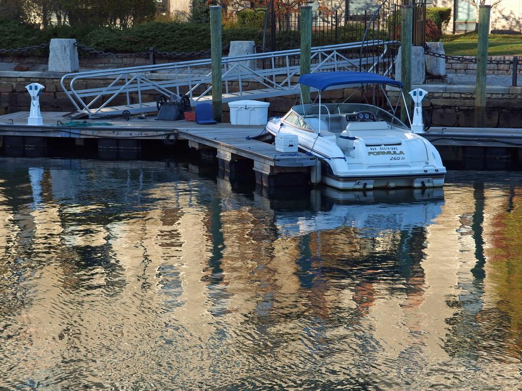 a quiet boat at dock by a Boston harbor-front apartment in a re-imagined old wharf building