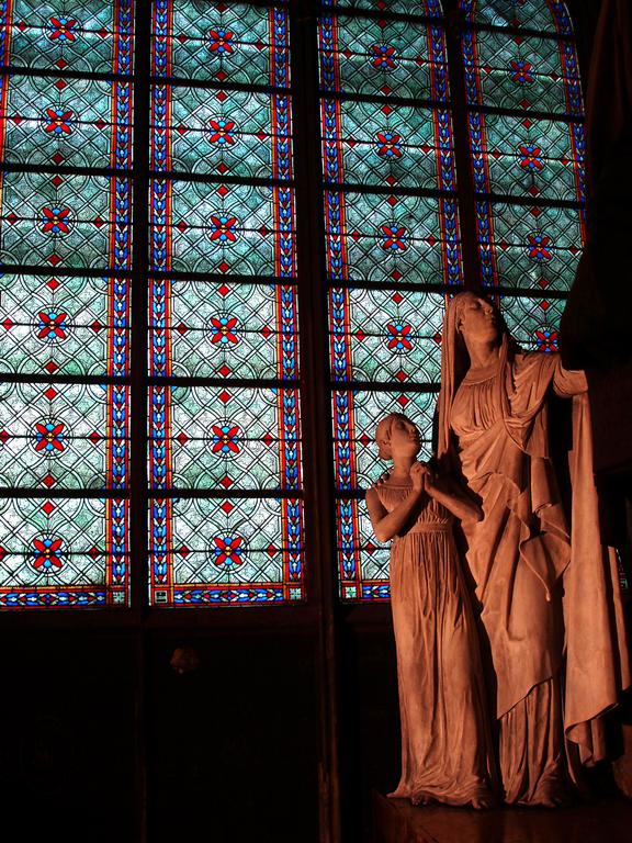 window and sculpture inisde Notre Dame Cathedral in Paris, France