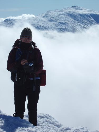 Judy stands out on the summit of Mount Adams with Mount Washington as a background in New Hampshire