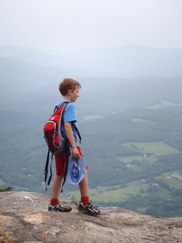 hiker at Brownsville Rock near the summit of Mount Ascutney in Vermont