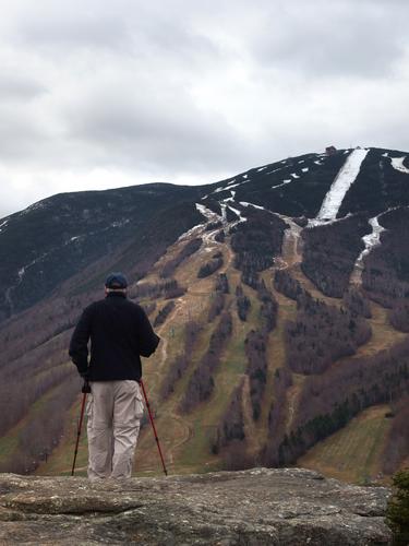 hiker on the summit ledge of Bald Mountain near Franconia Notch in New Hampshire