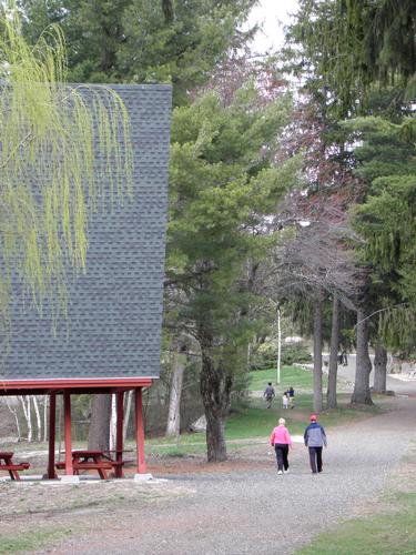 walkers passing the A Frame picnic pavilion at Benson Park in New Hampshire