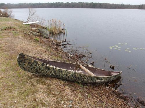 canoe on the edge of Burrage Pond at Burrage Pond Wildlife Management Area in eastern Massachusetts