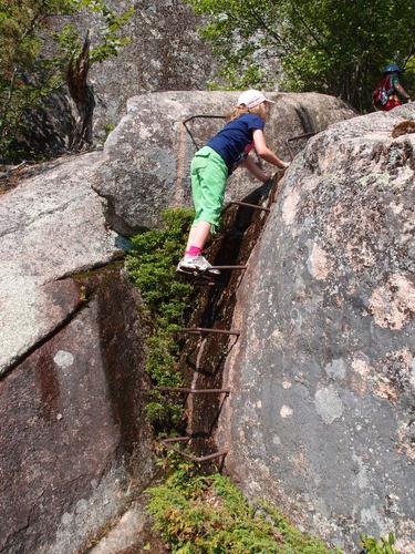 young hiker on the way to Cadillac Mountain on the Ladder Trail at Acadia National Park in Maine