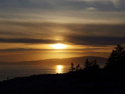 sunset over Champlain Mountain (left smaller bump) and Cadillac Mountain (right tallest bump) in Acadia National Park as seen from Schoodic Point