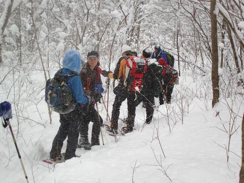 hikers in December on the snowy trail to Cherry Mountain in New Hampshire