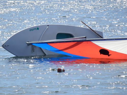 tipped Sunfish sailboat on Dublin Lake in New Hampshire