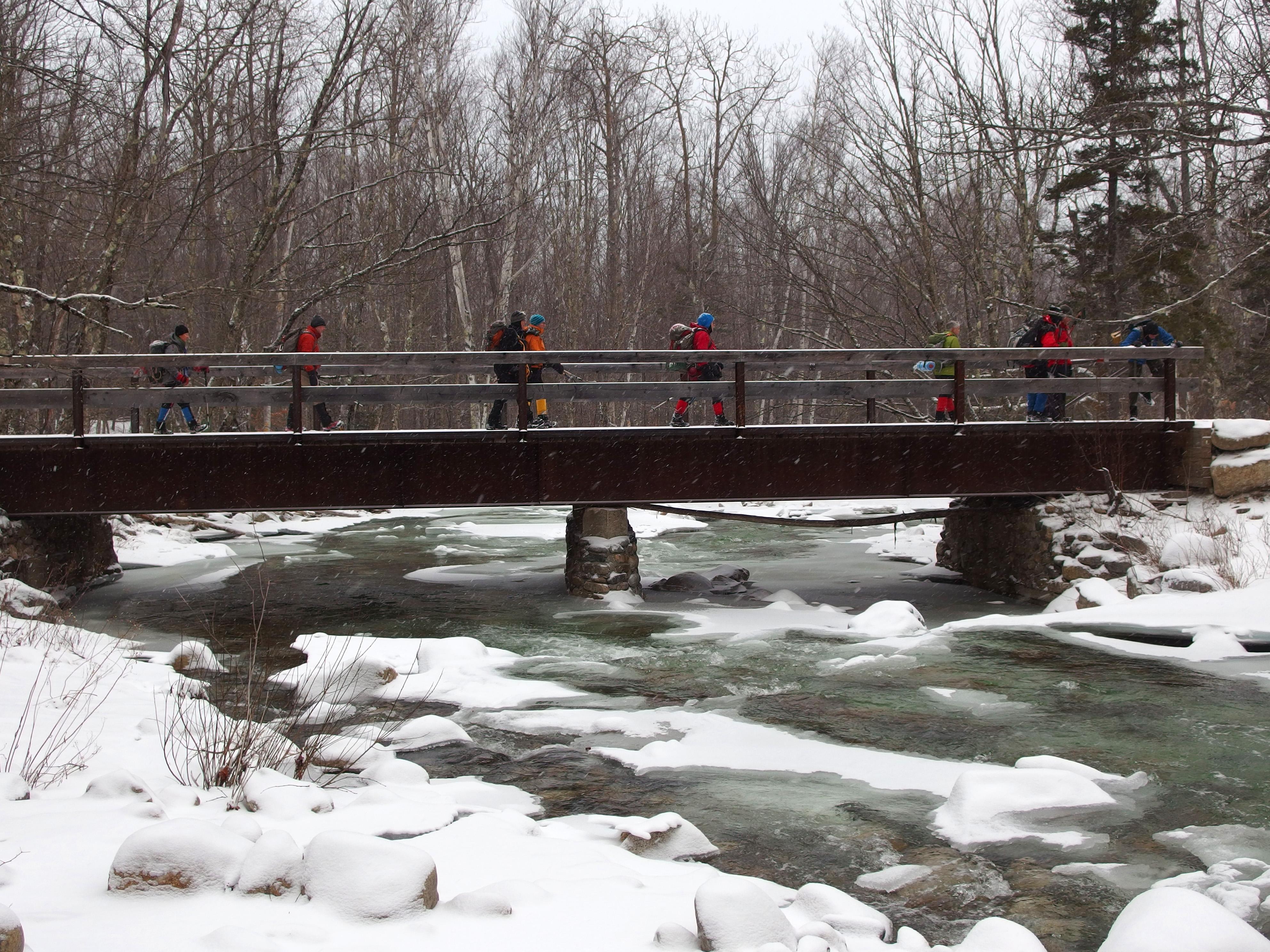 winter hikers crossing Little River on the way to Mount Hale in New Hampshire