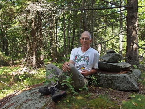 Fred poses for a photo at the summit cairn on Hutchins Hill in western New Hampshire