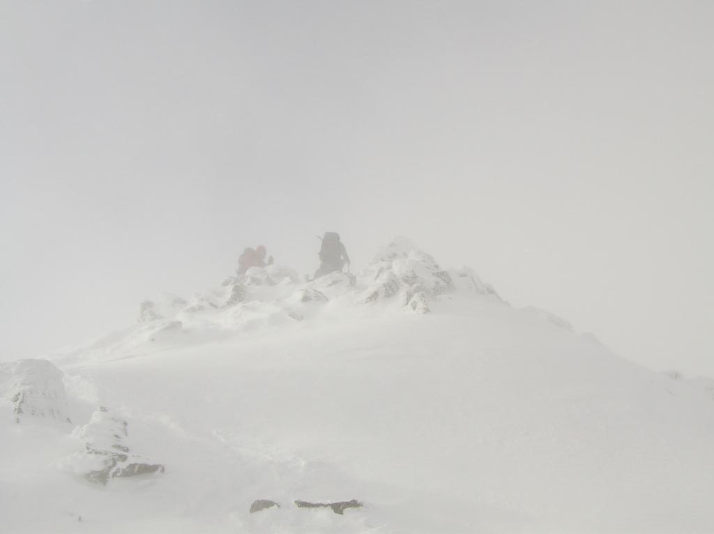 Joni and Mark ascend in December's white-out conditions to the cloud-covered summit of Mount Jefferson in the White Mountains of New Hampshire