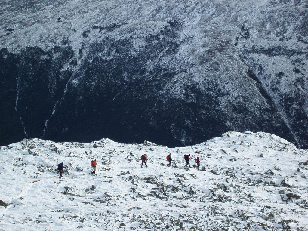 winter hikers in Sphinx Col with the Great Gulf and Mount Washington as a backdrop in the White Mountains of New Hampshire