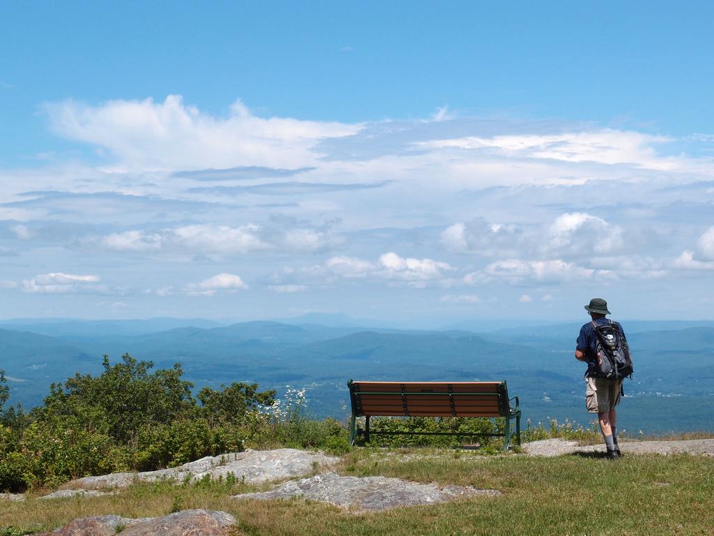 bench, hiker and easterly view from the near-summit lookout on Mount Everett in southwestern Massachusetts