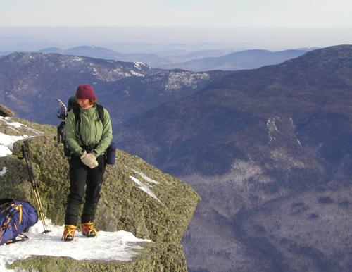 Rebecca stands out on the edge of Mount Madison in December in the White Mountains of New Hampshire