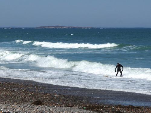 April surfer on Nantasket Beach at Hull in Massachusetts