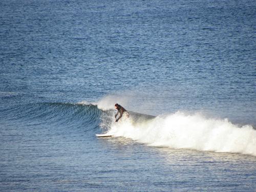 a wetsuit-clad surfer plays in the cold water off Ogunquit Beach in Maine