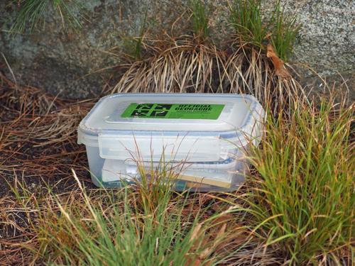 geocache box near the summit fire tower atop Pawtuckaway South Mountain in New Hampshire