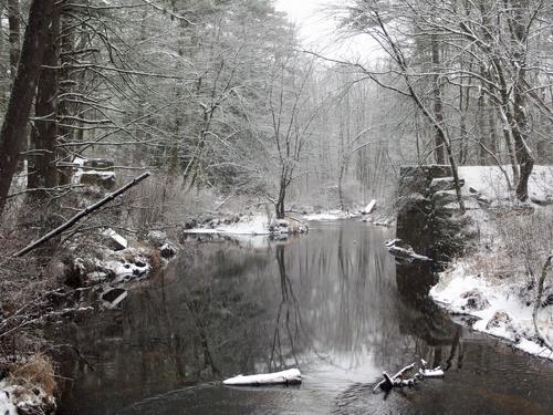 Nissitissit River flowing past the missing railroad bridge on the Potanipo Rail Trail in southern New Hampshire