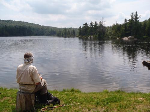 hiker at Smith Pond after returning from Prospect Hill in Enfield in New Hampshire