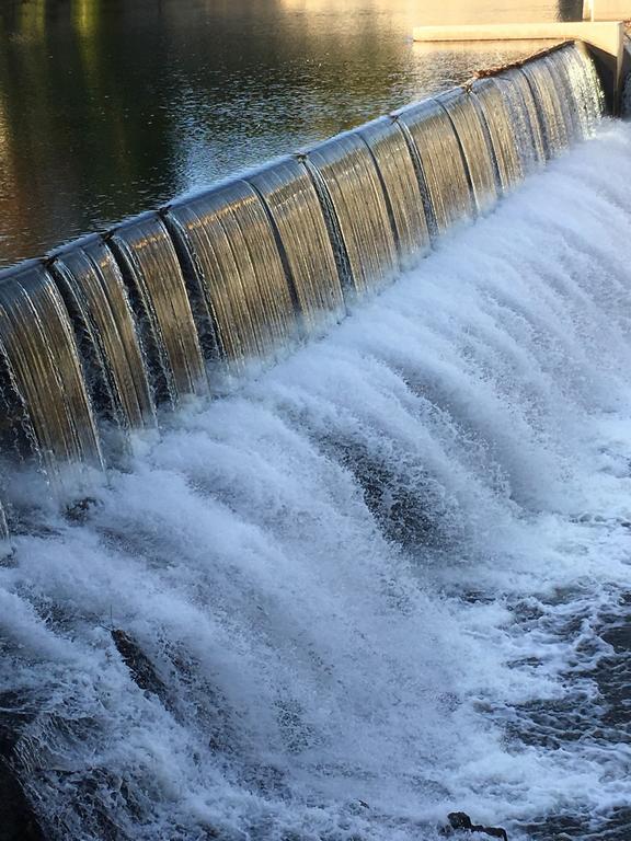 falls as seen from the south side of the river near the Library on the Nashua Riverwalk in New Hampshire