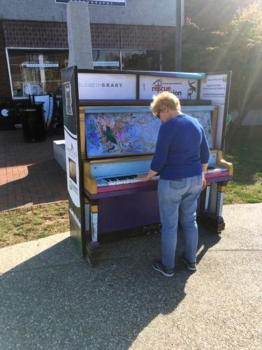 Andee plays a sidewalk piano on Main Street while on the Nashua Riverwalk in New Hampshire