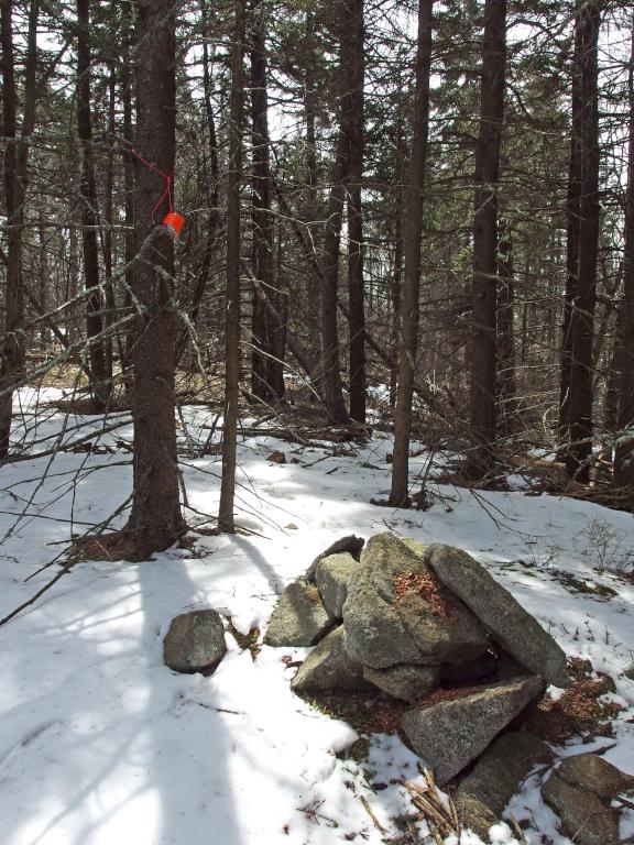 cairn and hiker register jar in April atop Holt Hill in southwestern New Hampshire