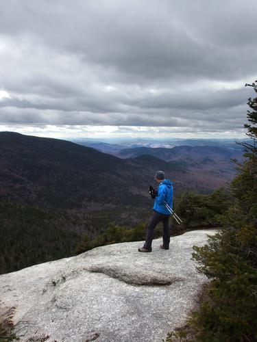 hiker and view from a lookout near Noon Peak in New Hampshire