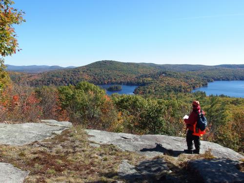 Chuck stands out on Mount Shannon's ledge to take in the view of Hills Pond and Avery Hill near Lake Winnipesaukee in New Hampshire