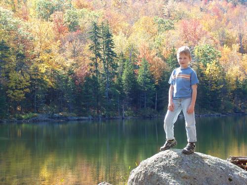 hiker at Jack's Pond on the way to Thumb Mountain in New Hampshire