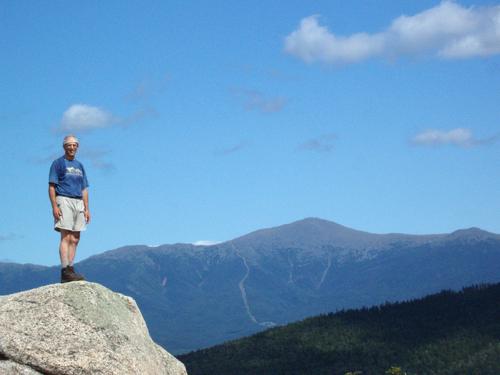 hiker on the summit of Middle Sugarloaf Mountain in New Hampshire