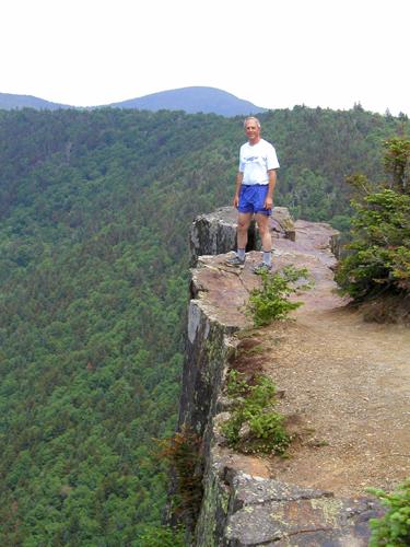 hiker on the edge of Table Rock in New Hampshire