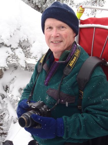 winter hiker on the summit of Mount Tecumseh in New Hampshire