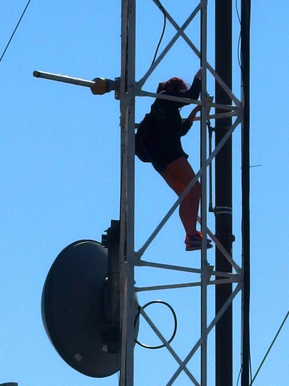 a college student climbs one of the antennas on the summit of Mount Tom in western Massachusetts