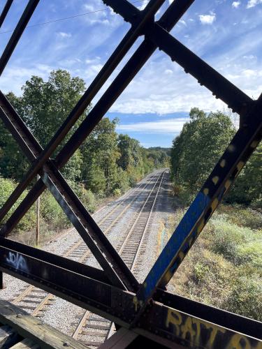 John walks his bike across a bridge in October at Wayland Rail Trail near Wayland in eastern MA