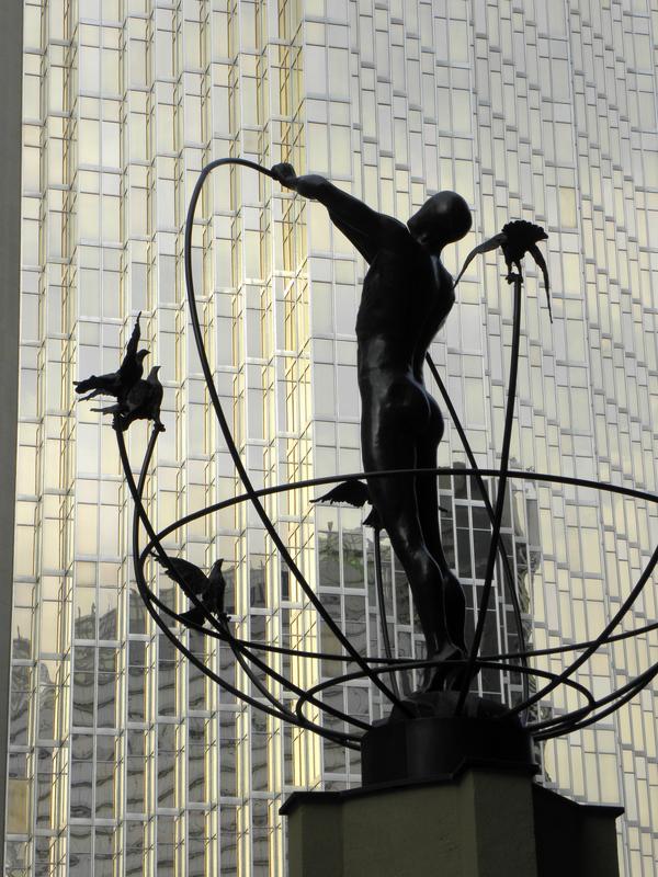 statue and golden skyscraper at Toronto in Canada